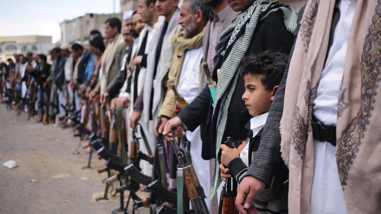 A child joins his father at a tribal meeting in Hasaba, where pro-Houthi tribes gather to show their allegiance