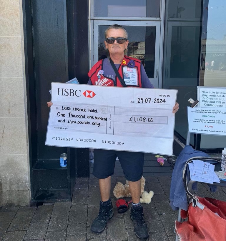 Big Issue vendor Nick Cuthbert holding a giant cheque