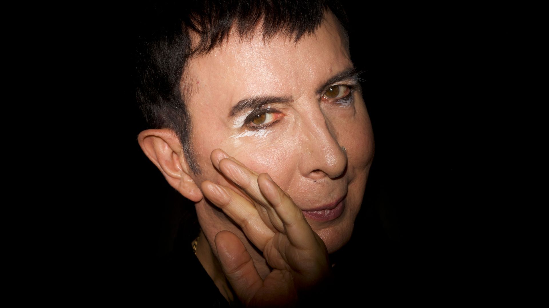 English singer Marc Almond in a low-lit photo with a black background