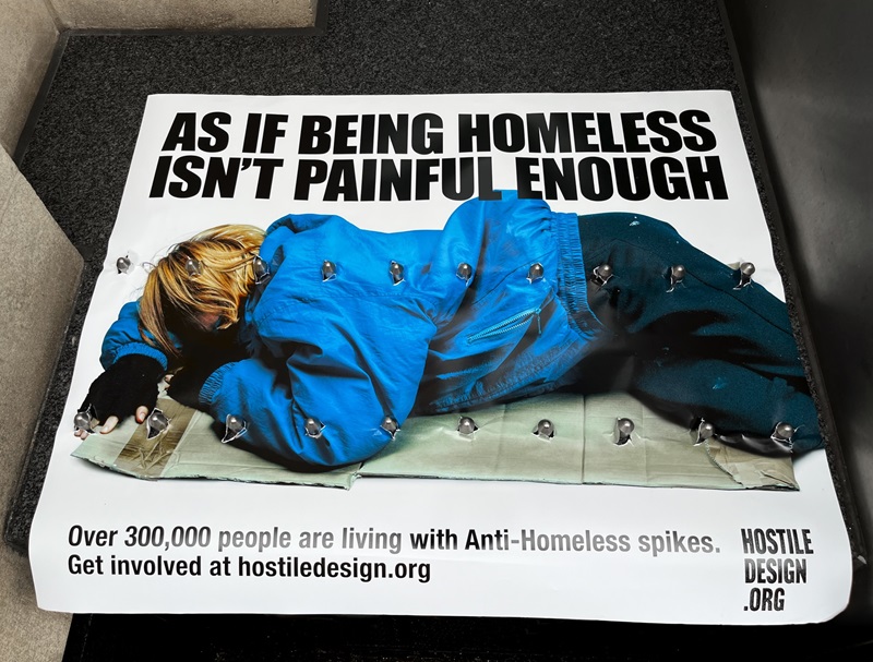 Poster of a homeless person pierced by spkes designed to deter rough sleepers, known as hostile architecture