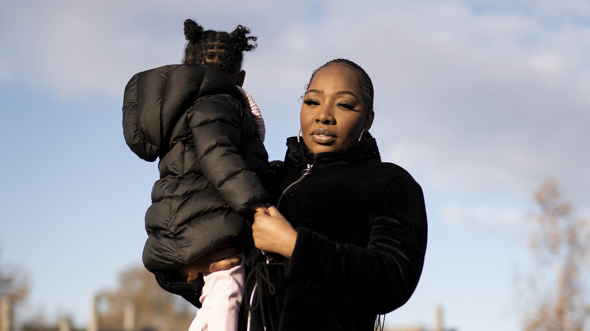 A woman who is experiencing homelessness holding her daughter