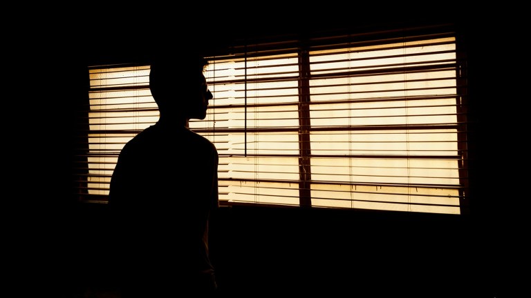 silhouette of person looking out of the window