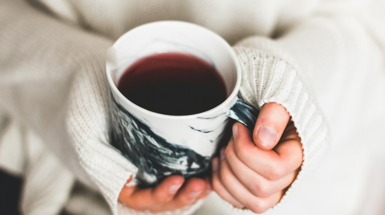 A woman's hands holding a cup of tea