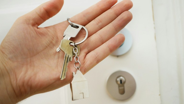 A hand holding house keys. Thousands of Brits need help with rent during the housing crisis