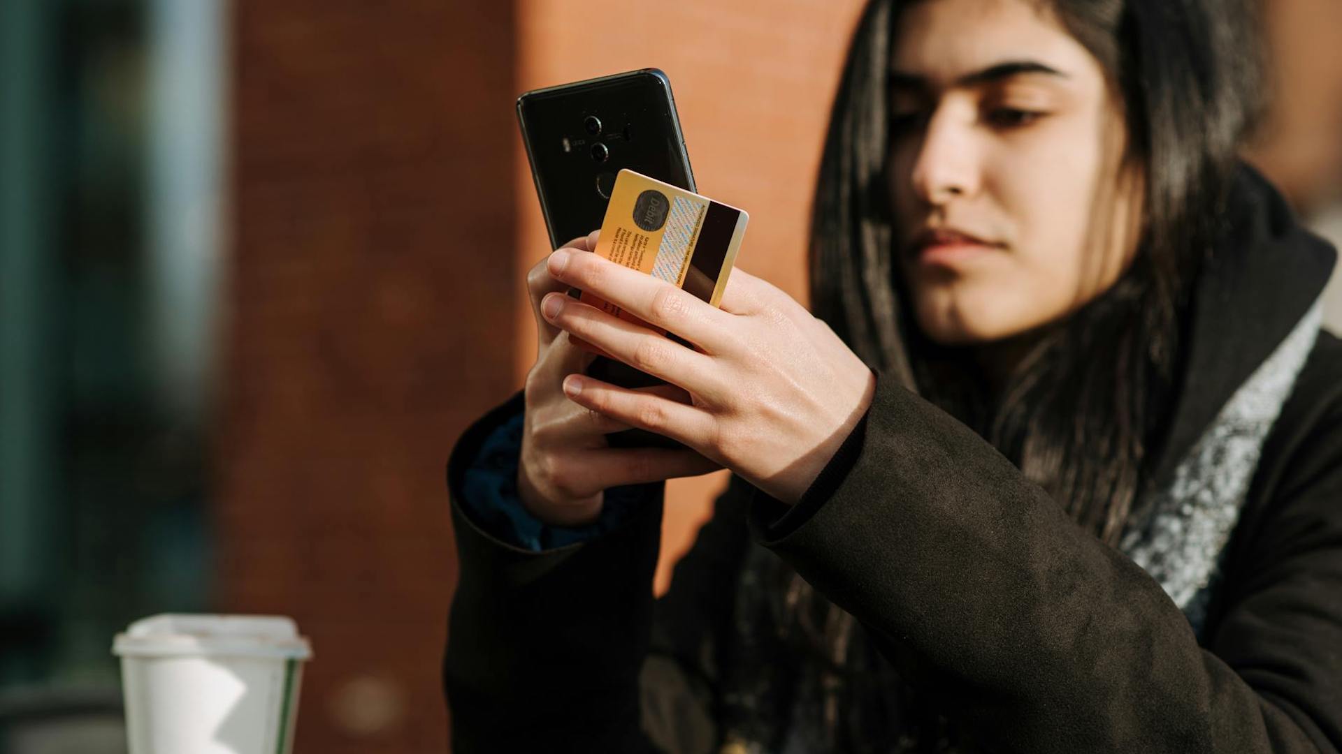 a woman holding a mobile phone and a bank card. how long does a landlord have to return a deposit