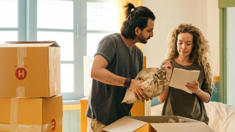 A man and woman surrounded by cardboard packing boxes. How to rent
