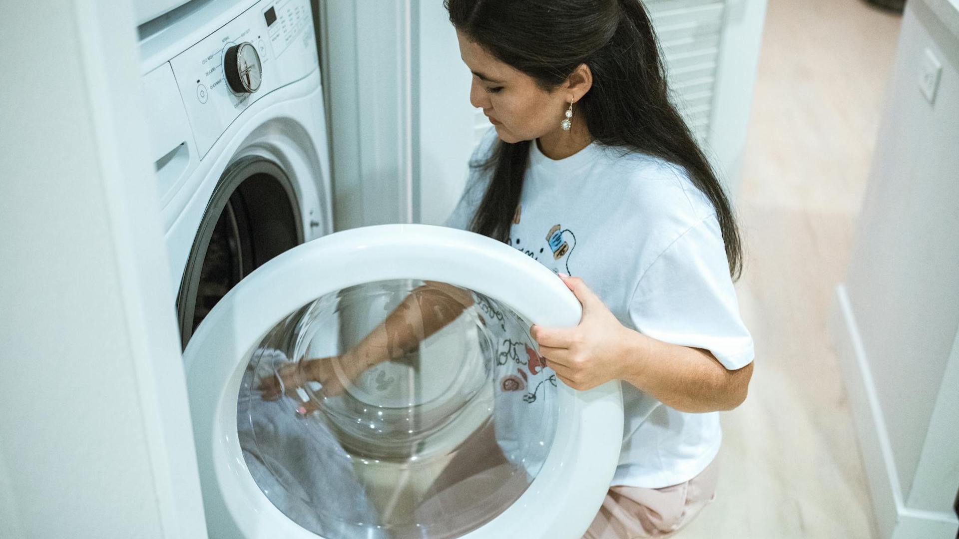 A woman loading laundry into a washing machine. How to set up bills when renting