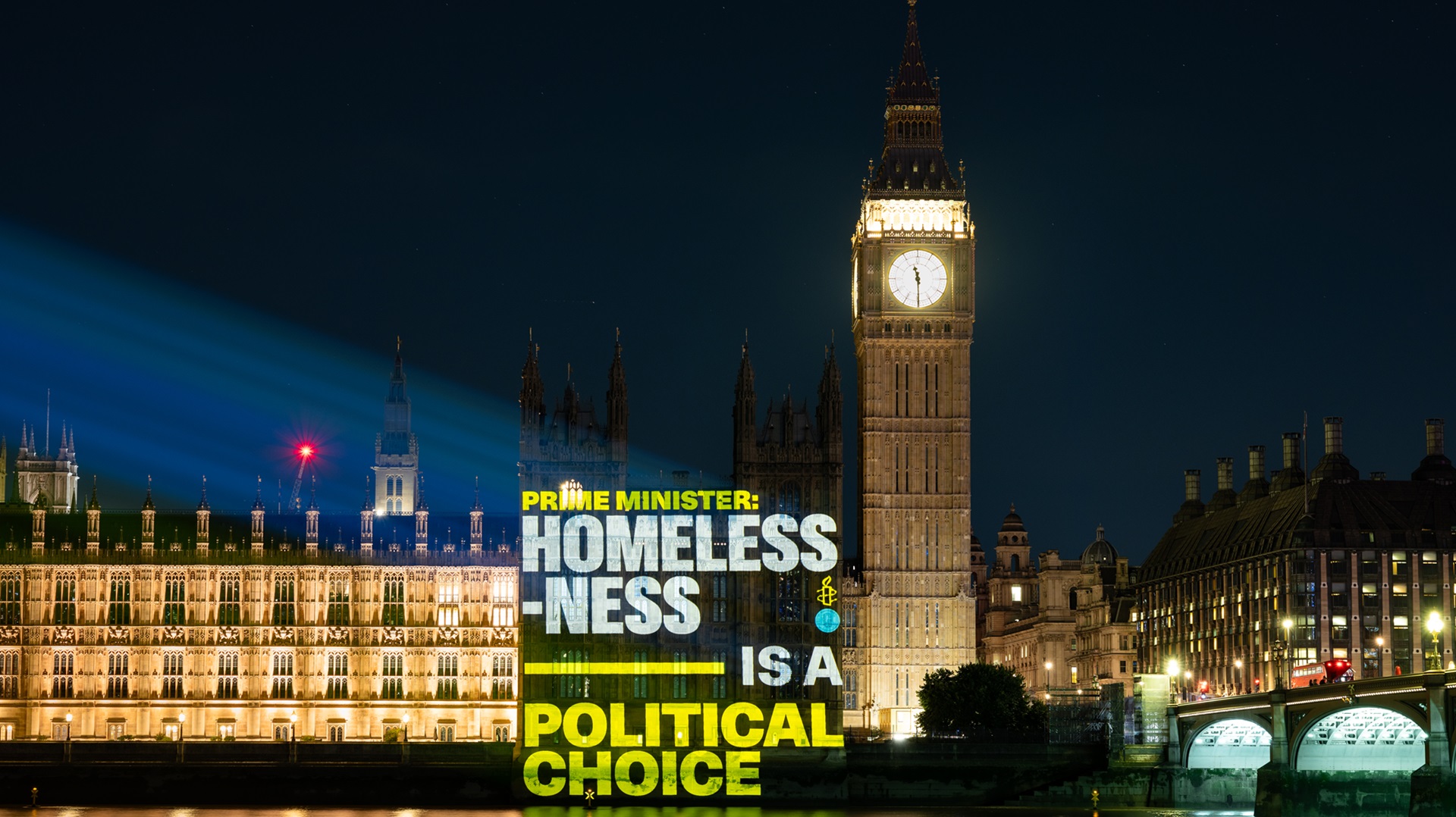 A message saying 'Homelessness is a political choice' is beamed on to the Houses of Parliament