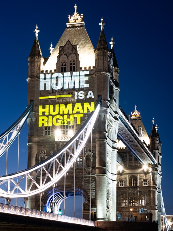 A message saying 'Home is a human right' is beamed on to Tower Bridge