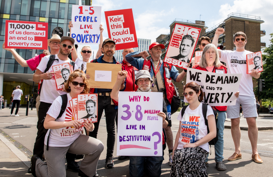 Group of big issue vendors and campaigners gathered holding signs calling for an end to poverty