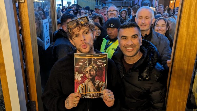 Tom Grennan holds a copy of the Big Issue magazine