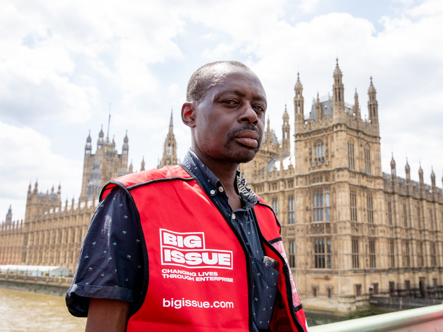 Big Issue vendor stands in front of the houses of parliament