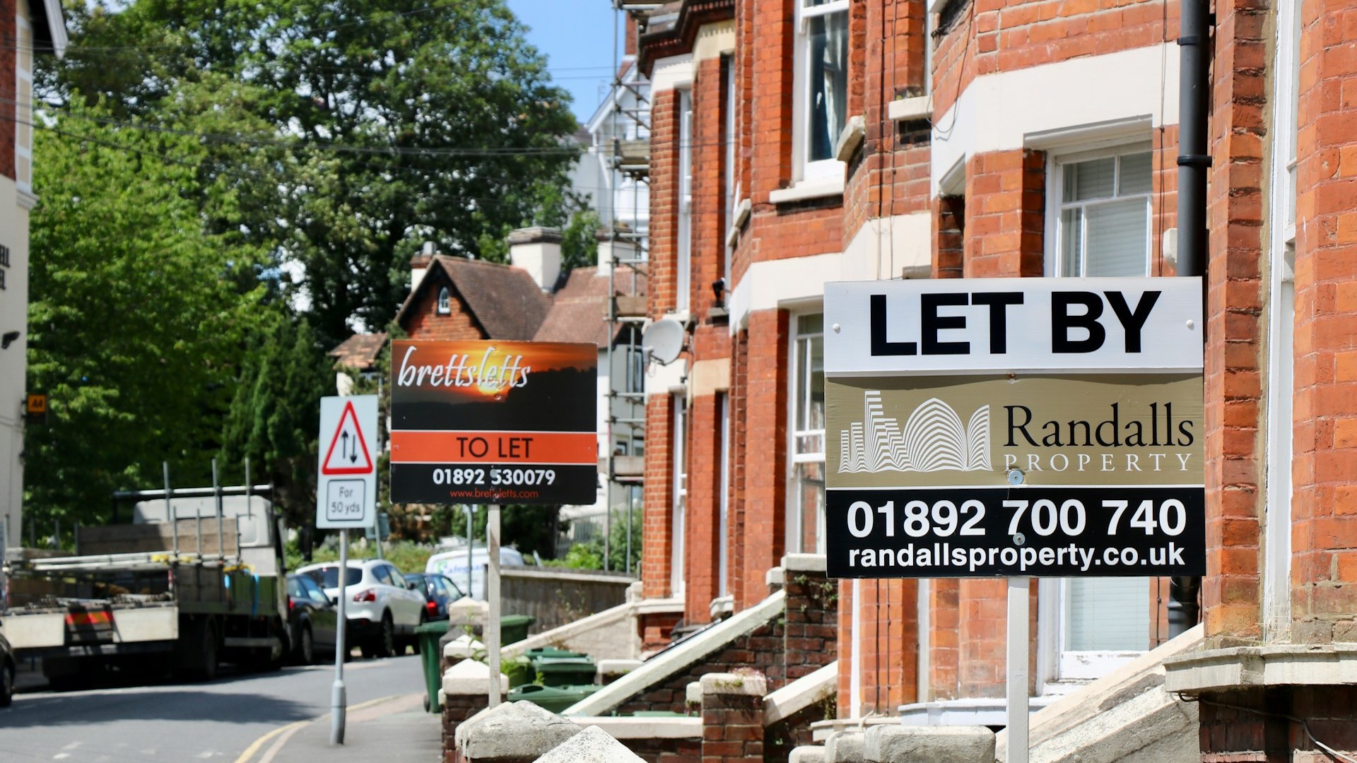 A to let sign outside a row of houses