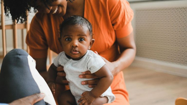 Stock image of a baby being held by its mother