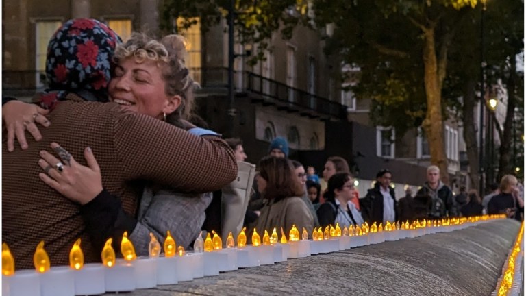 Two people hugging outside Downing Street at a vigil. The Museum of Homelessness recorded 1,474 deaths - a 12% increase compared to 2022. Image: Lucinda MacPherson.