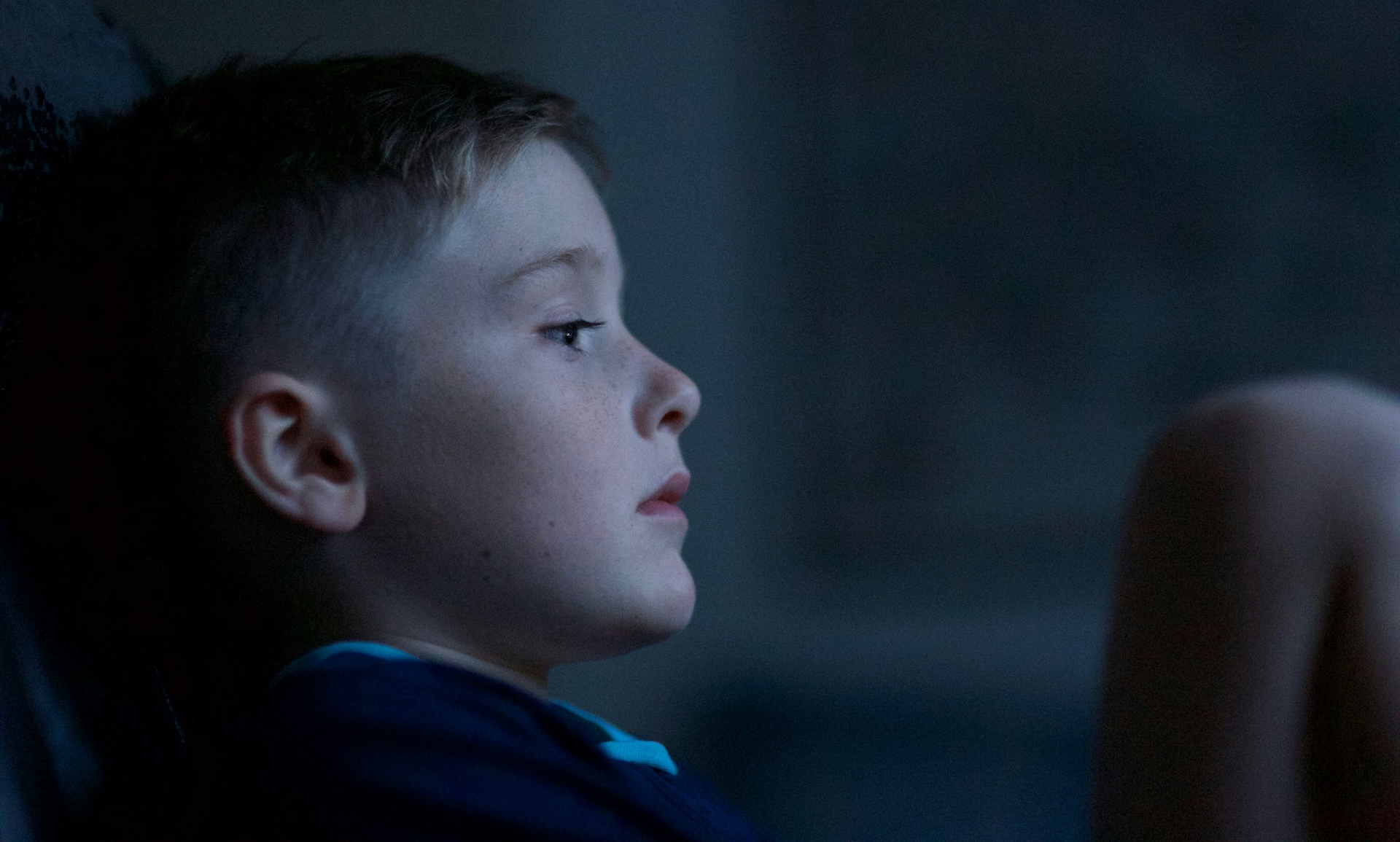 boy leaning back on a wall looking sad