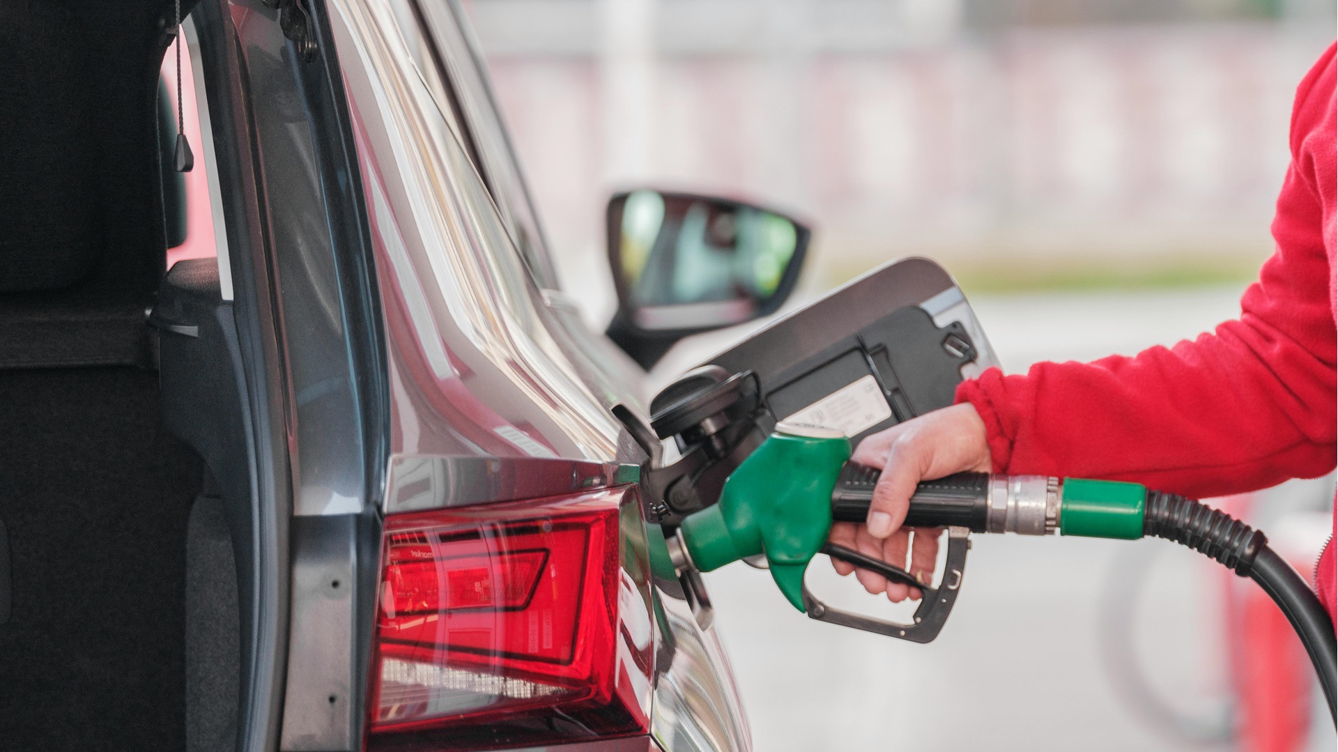 a person filling up their car at a fuel pump