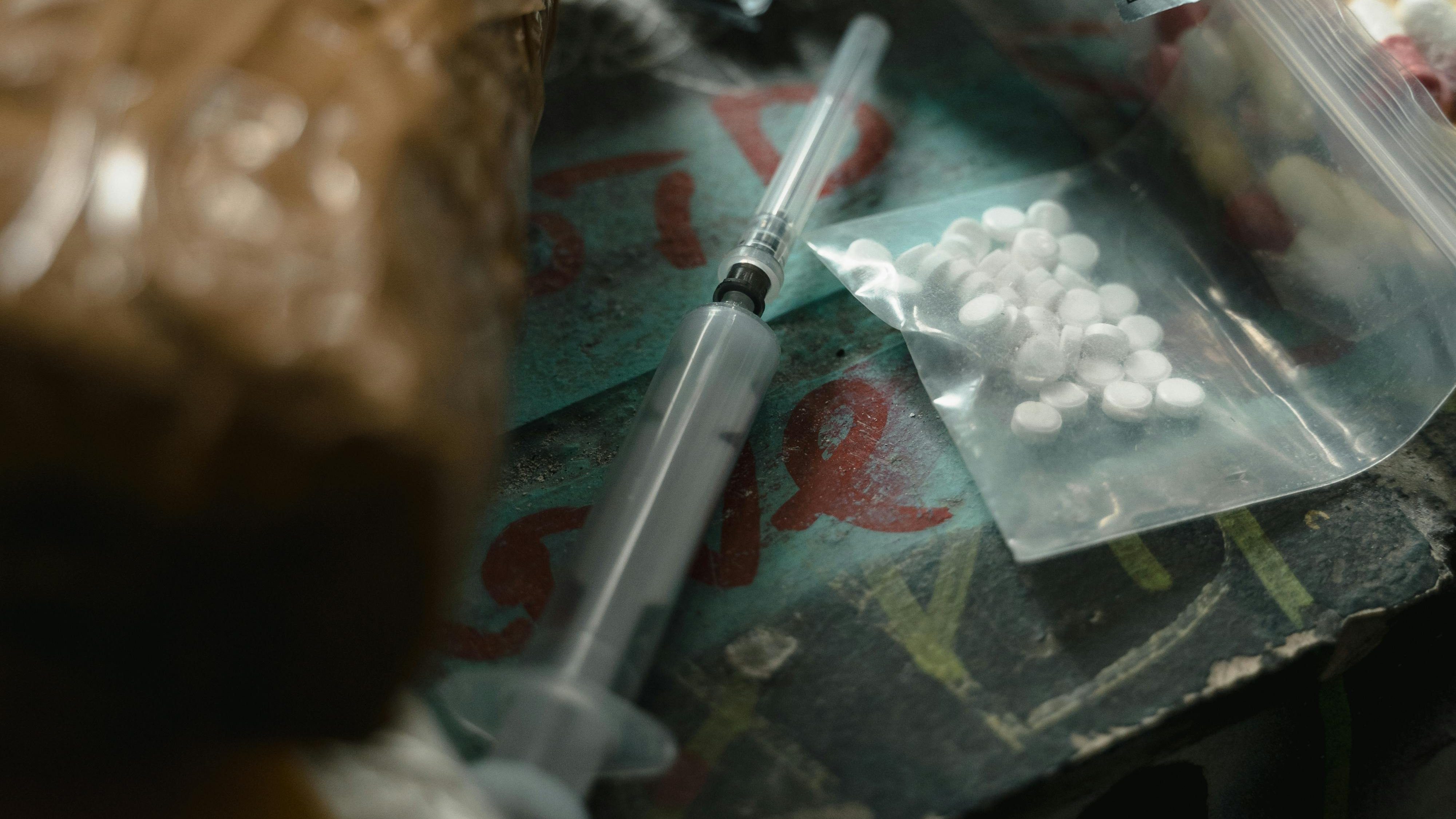 a syringe and pills of drugs