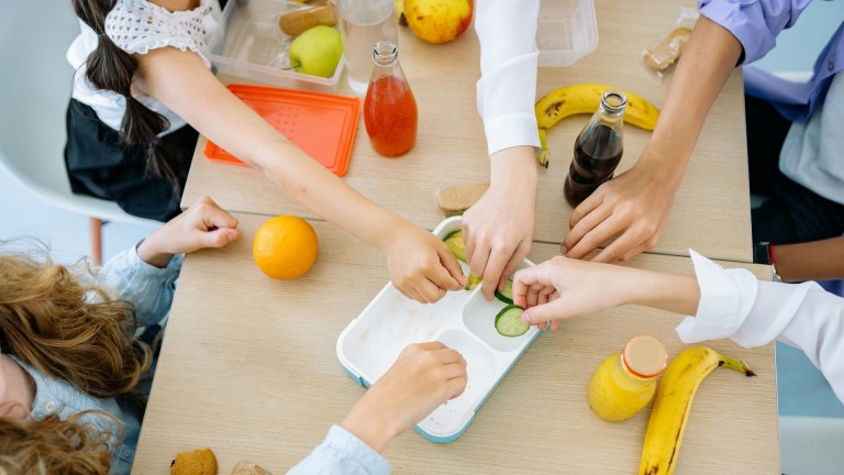 children grabbing food off table