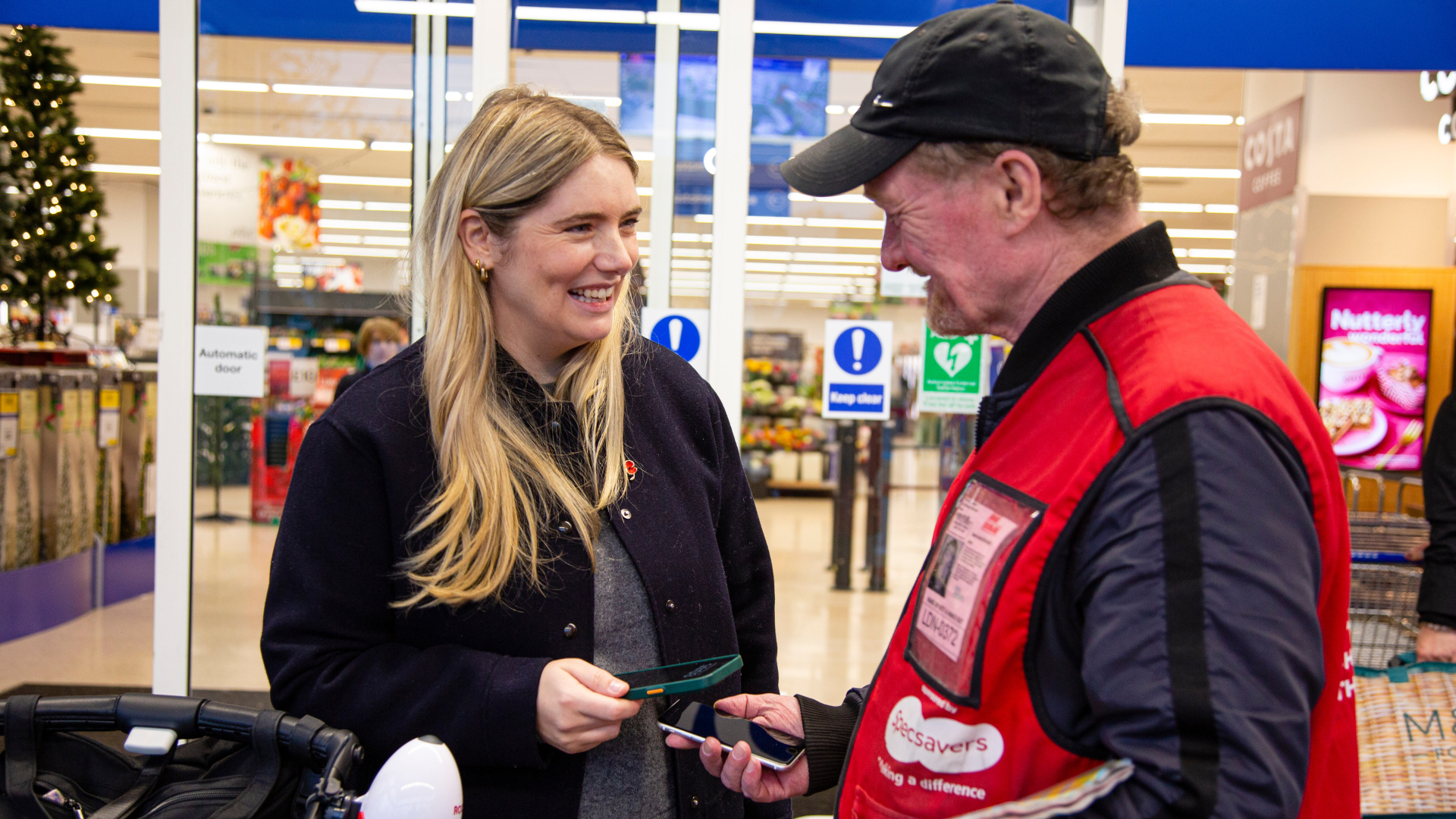 Hammersmith Big Issue vendor Dave Martin uses his giffgaff phone to take a contactless payment. Credit Andy Parsons