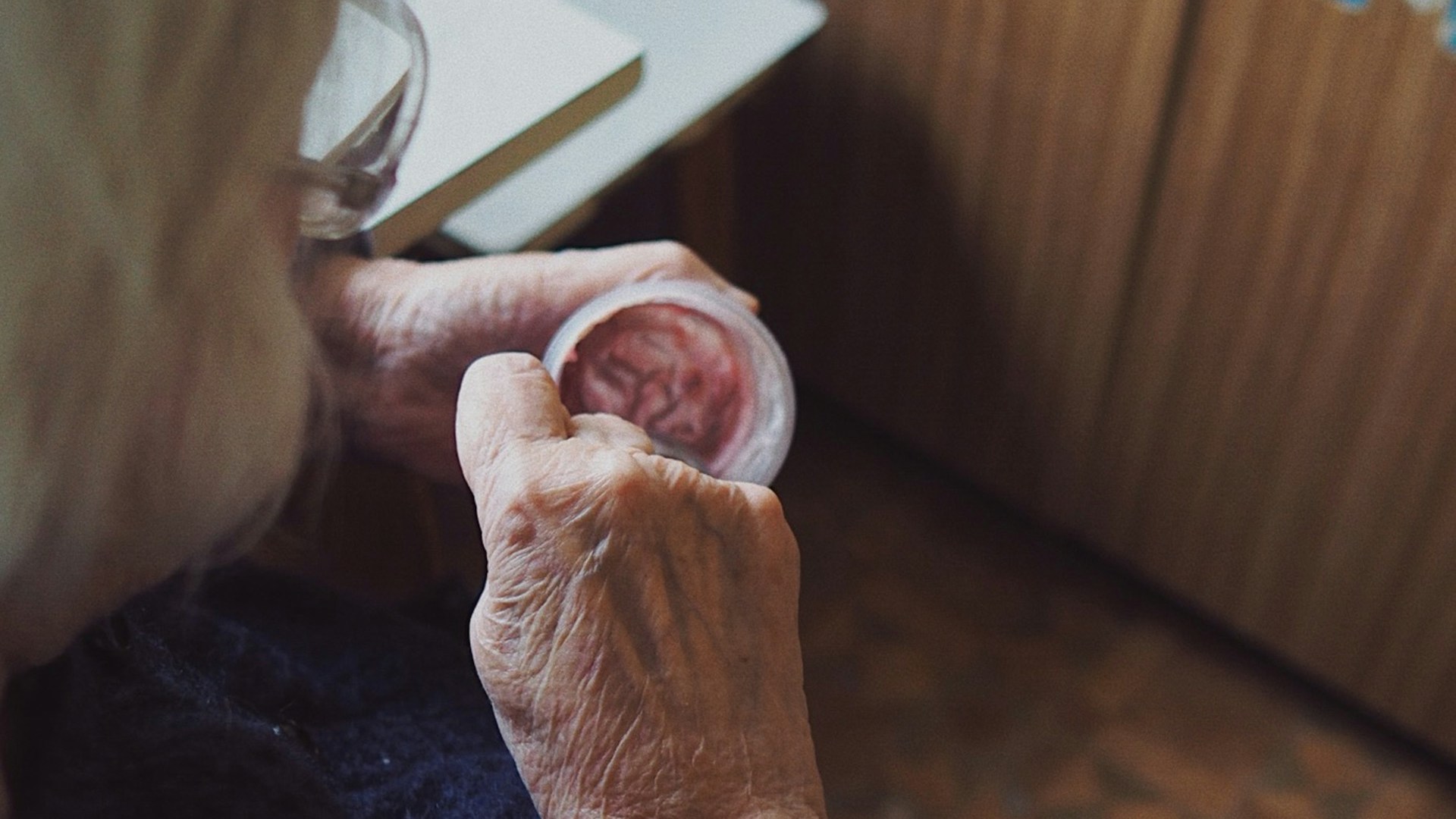 a view from above of an older person with white hair eating out of a pot