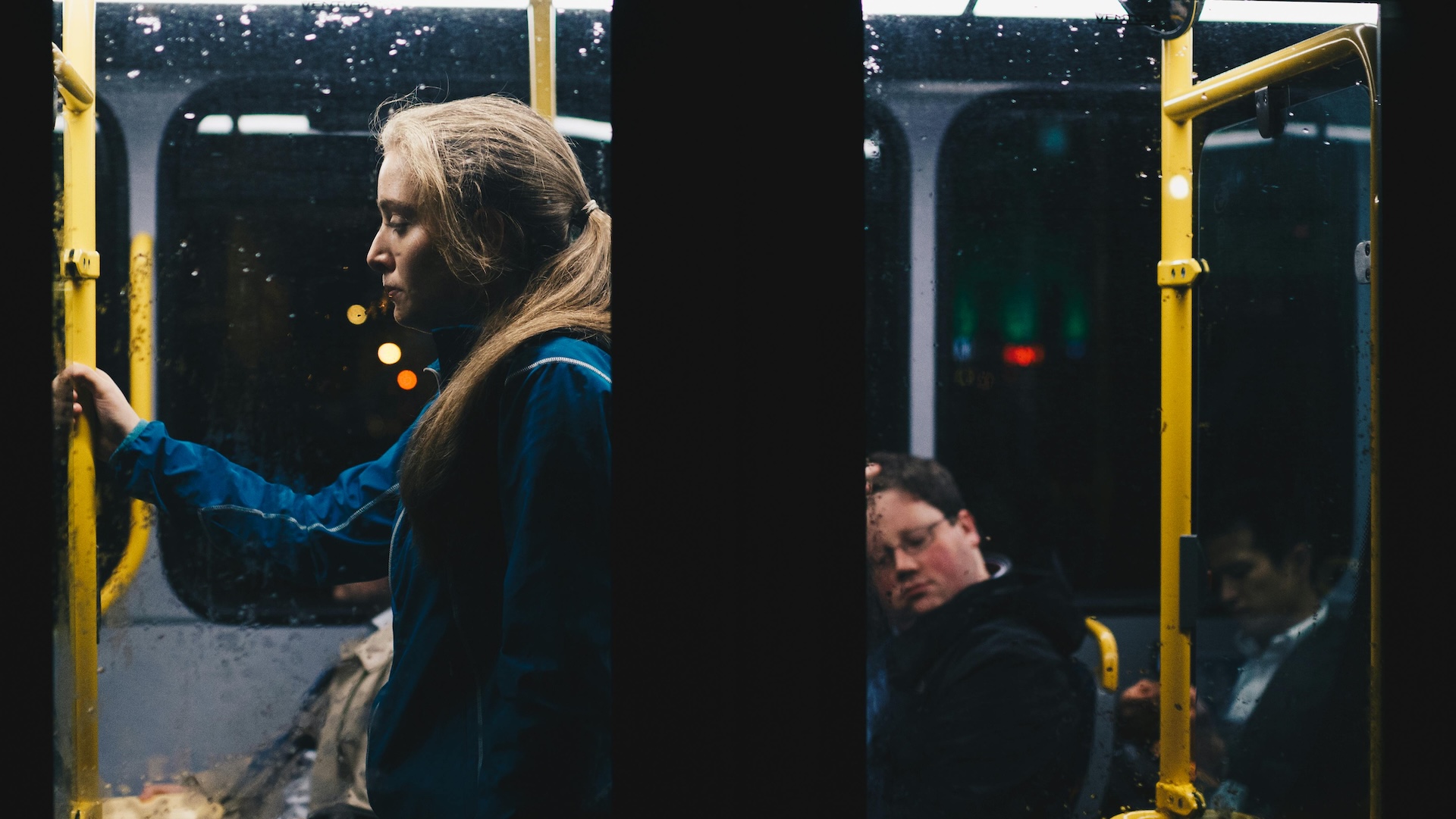 A stock image of a woman getting a bus at night.