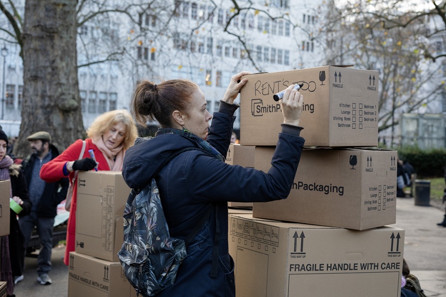 Renters pile up and write on cardboard boxes