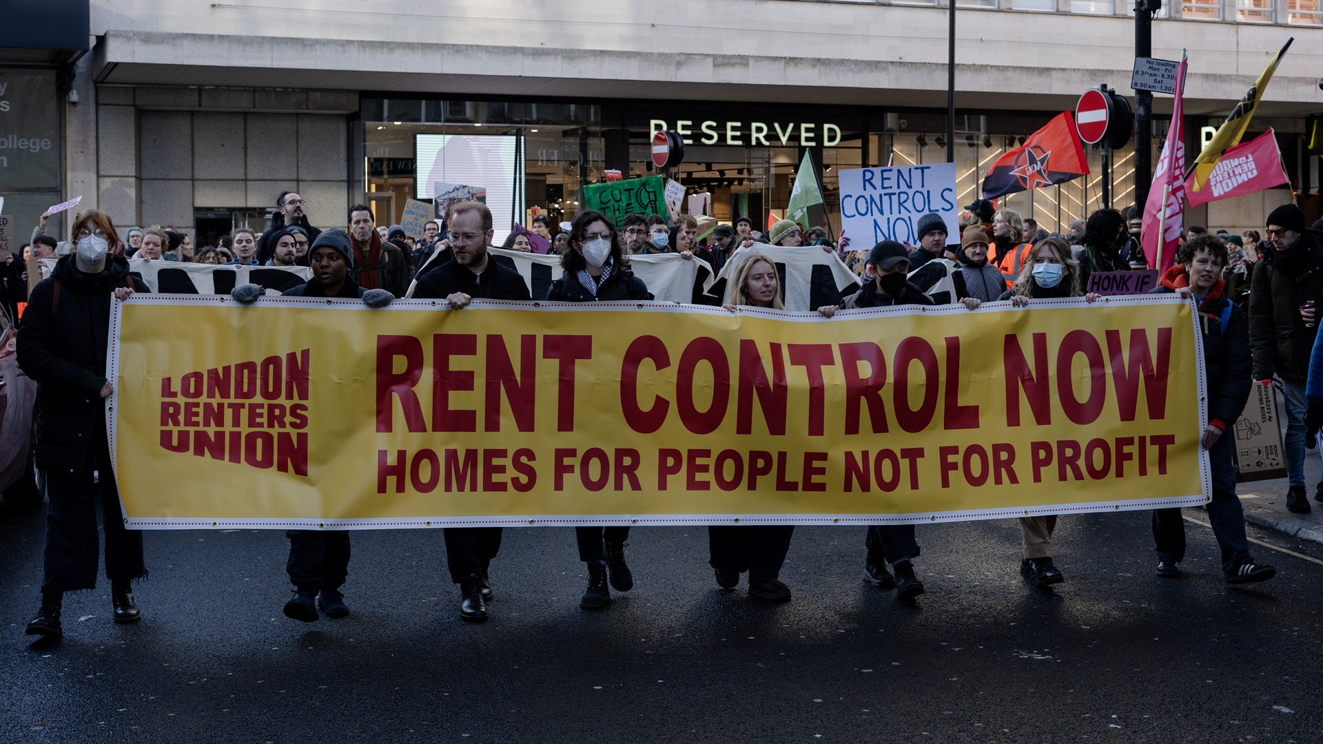 Renters march down London's Oxford Street holding a banner demanding 'rent controls now'