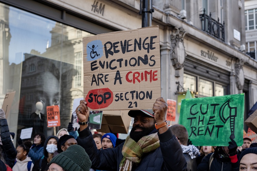 A renters holds up a placard calling for an end to no-fault evictions