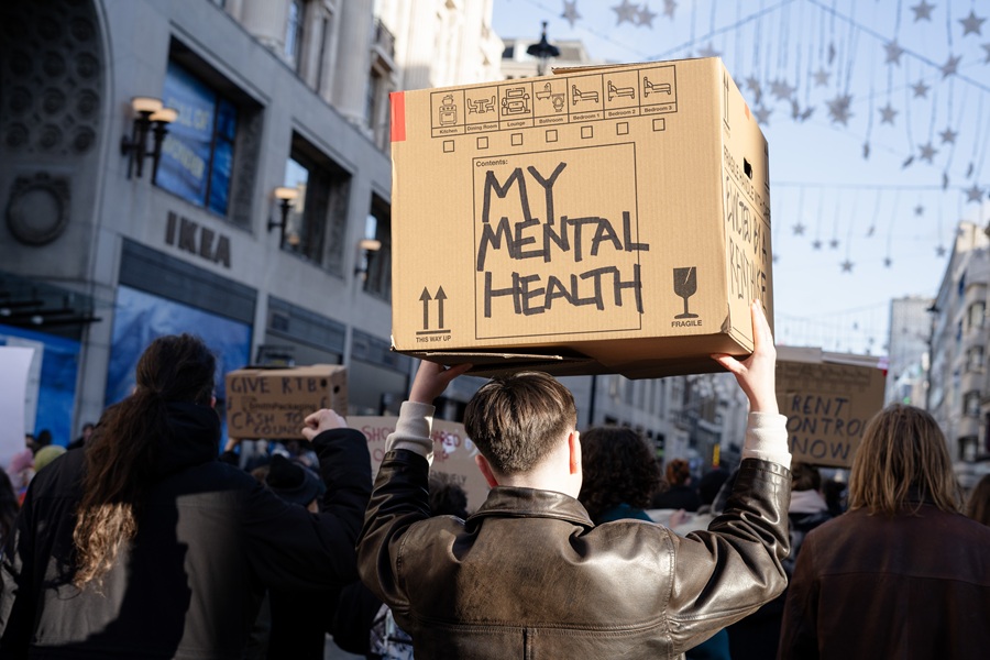 A renter holding a cardboard box reading 'My mental health'