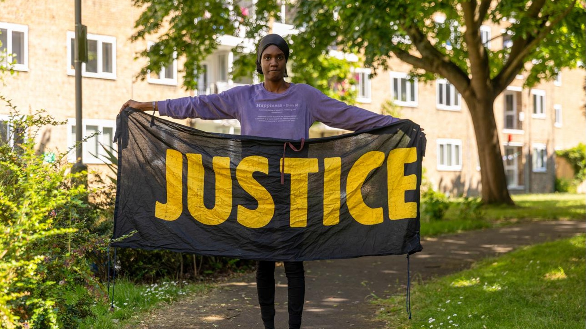 A woman holding a banner reading 'Justice'