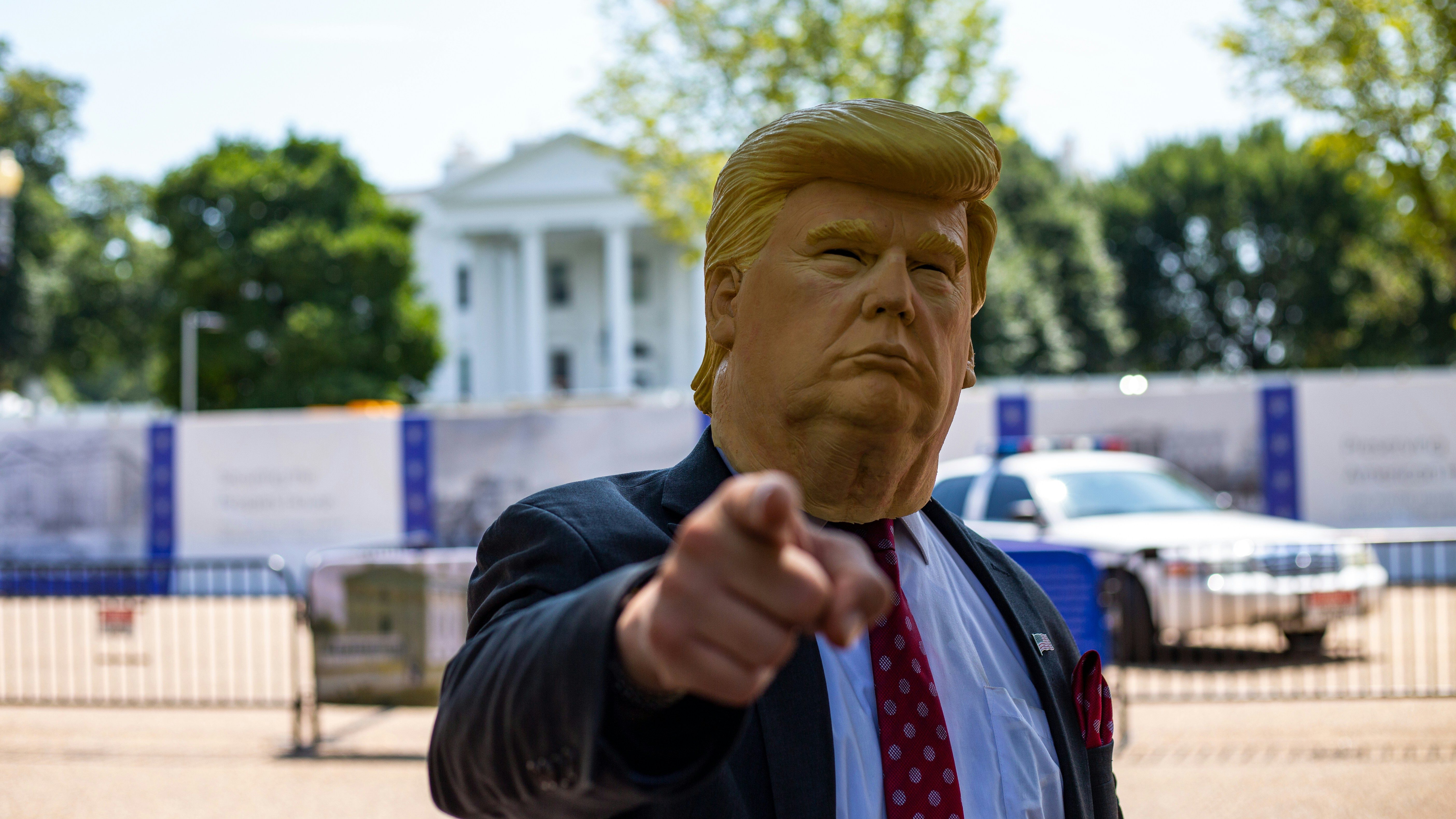 A man in a Donald Trump mask