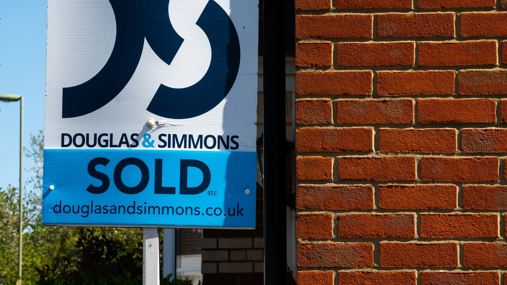 a sold sign outside a red-brick building