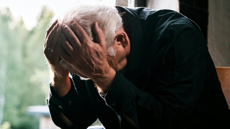 pensioner with his head in his hands