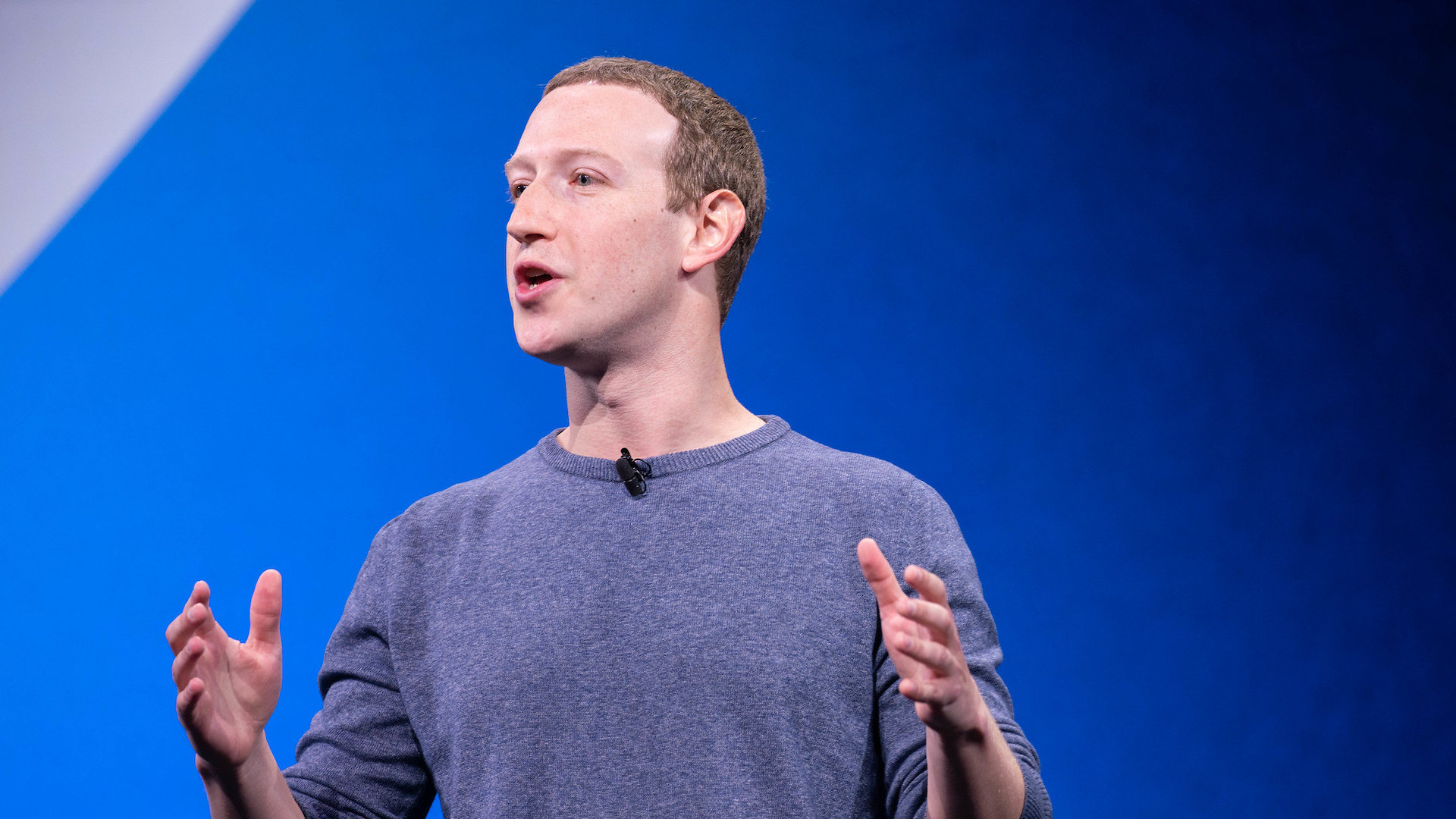 mark zuckerberg making a speech while stood against a blue background