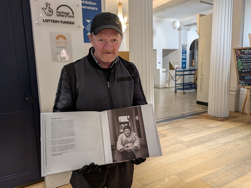 Big Issue vendor Dave Martin looking at his portrait during at the Outsiders project exhibition