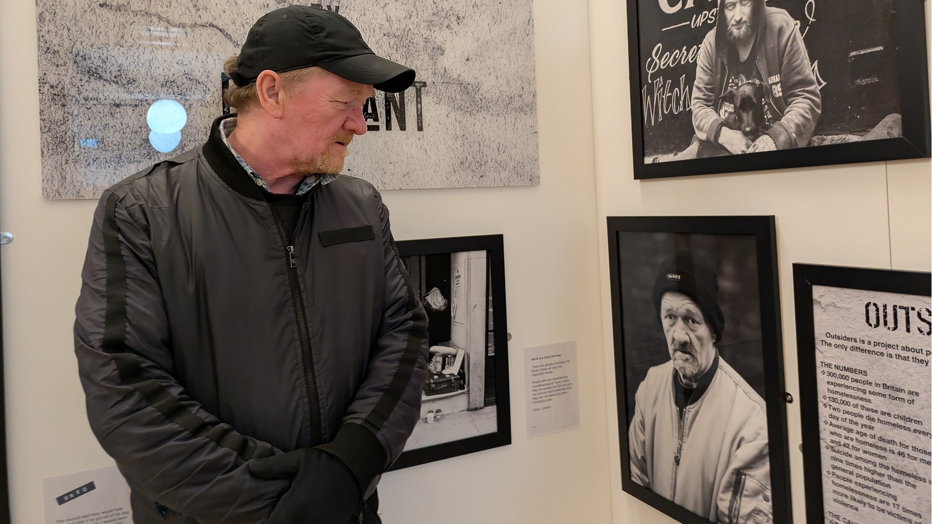 Big Issue vendor Dave Martin looking at his portrait during at the Outsiders project exhibition