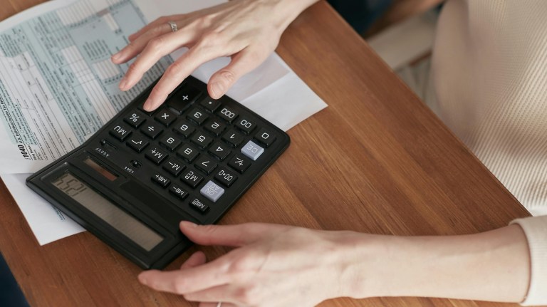 a person paying bills with a calculator