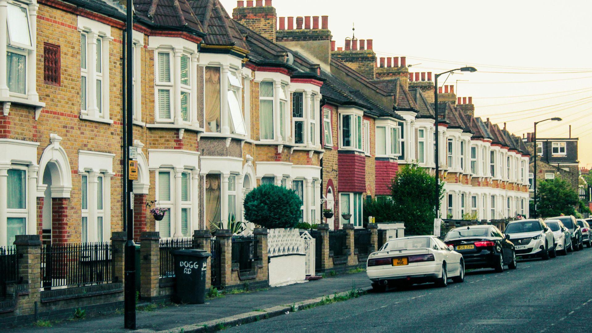 Row of terraced houses with cars on the road in front