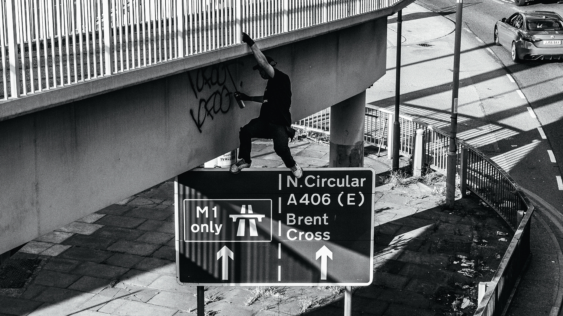 Graffiti writer 10Foot hangs off a road bridge to tag it