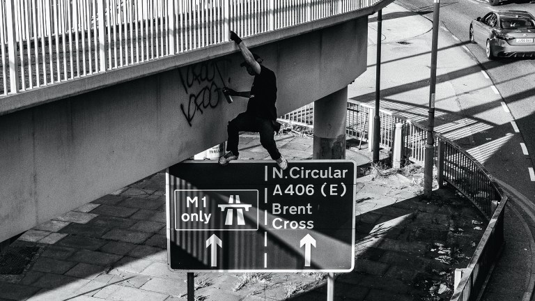 Graffiti writer 10Foot hangs off a road bridge to tag it